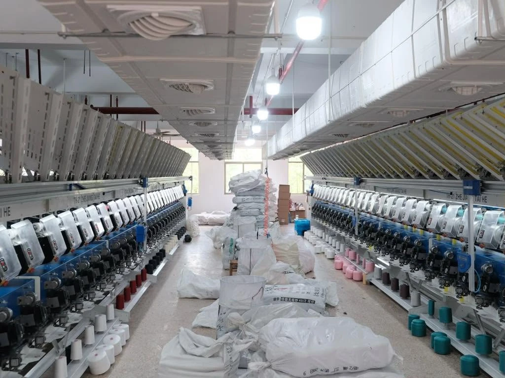 Rows of thread-production equipment inside the Jingcai workshop.